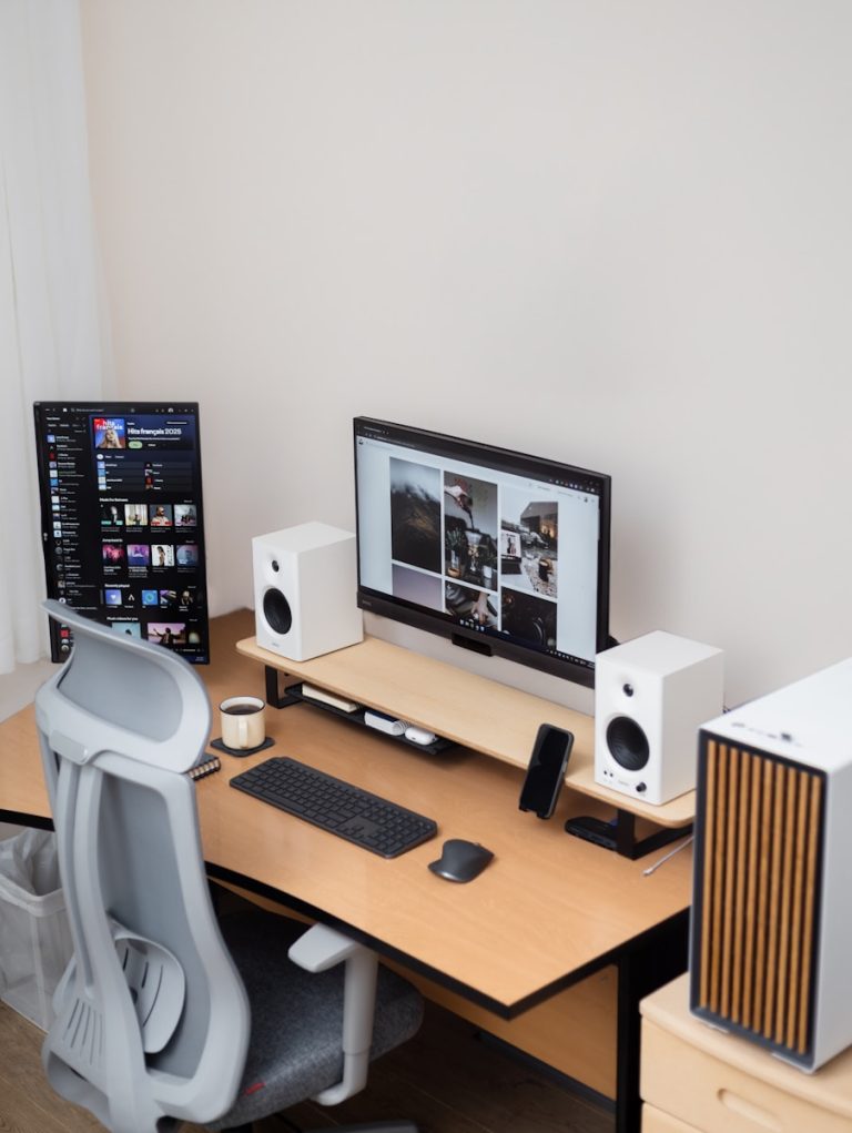 Modern desk setup with a monitor and two screens.